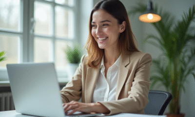Jeune femme souriante au bureau en train de naviguer sur social media